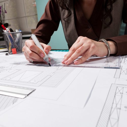 Close up of architect hands working on blueprints. Business and creativity. Architecture job